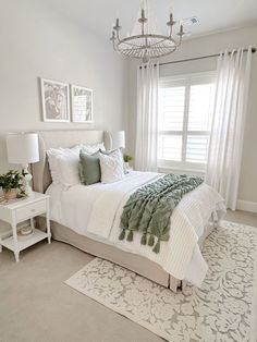 a bedroom with a bed, rug and chandelier