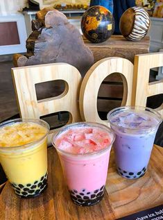 three drinks are sitting on a table with the word pop spelled out in large letters