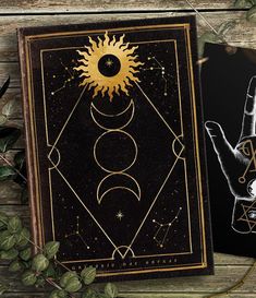 two cards with hand and sun on them, one is black and the other is gold