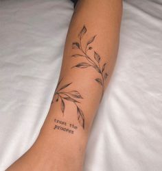 a woman's leg with a tattoo saying trust the process on her left arm