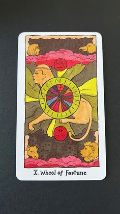 the wheel of fortune card is displayed on a black surface with red, yellow and green colors