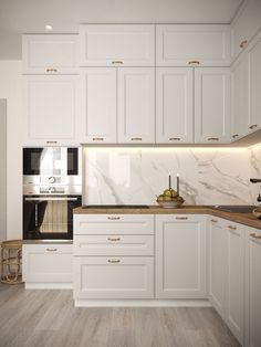 a kitchen with white cabinets and marble counter tops