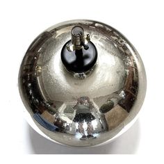 a shiny metal bowl with a black knob on the top and silver trim around it