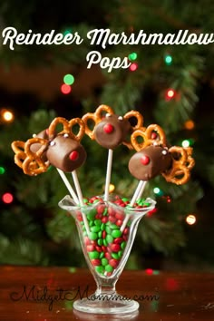 reindeer marshmallow pops in a glass vase with christmas candies and pretzels