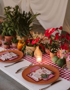 a table set with place settings and flowers