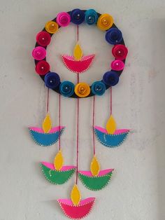 colorful paper quillings are hanging on a wall with circular circles and flowers in the center