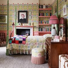 a bedroom decorated in pink, green and yellow with a fireplace on the far wall