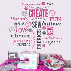 a sewing machine sitting on top of a pink table next to a wall with words written all over it