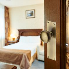 a hotel room with a bed and a door handle on the front side of it