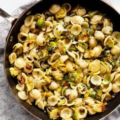 a skillet filled with pasta and vegetables