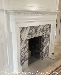 a white fireplace with black and white marble