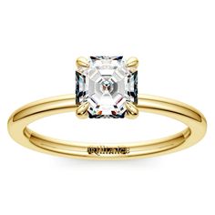 a yellow gold engagement ring with an assorted white topazte stone in the center