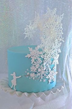 a blue frosted cake with white snowflakes on it