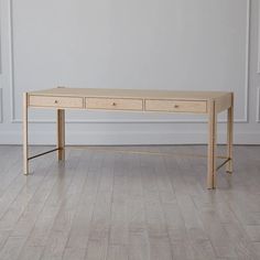 a wooden table with two drawers on top of it in an empty room next to a white wall