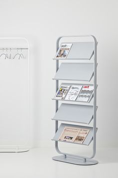 a magazine rack sitting next to a white refrigerator