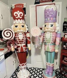 two nutcrackers are standing next to each other in the kitchen, one holding a lollipop