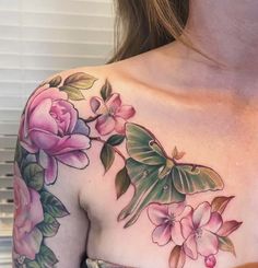 a close up of a woman's chest with flowers and a butterfly on it