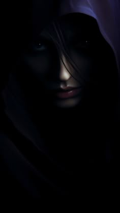 a woman's face is lit up in the dark with her head covered by a veil