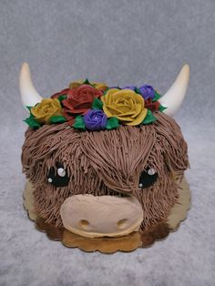 a cake shaped like a cow with flowers on its head