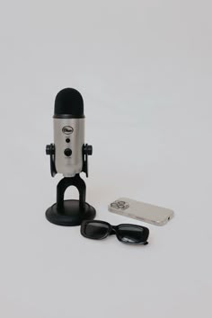 a microphone, sunglasses and cell phone on a white background with space for text or image