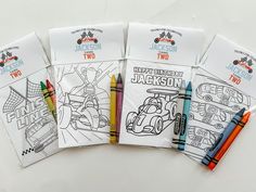 four coloring books with crayons on top of them and two pens next to each other