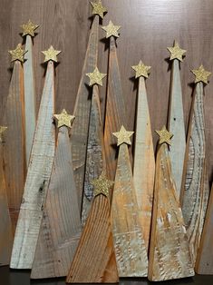 several wooden christmas trees with gold stars on them