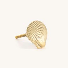 a gold seashell ring on a white background