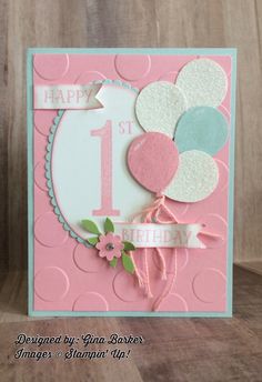 a birthday card with balloons and a number one on the front, sitting on a table