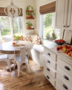 a kitchen filled with lots of furniture and fruit on top of a countertop next to a window