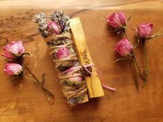 dried flowers are tied up on a wooden table