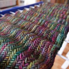 a multicolored knitted blanket sitting on top of a table