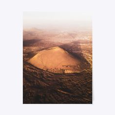 an aerial view of the desert with hills in the distance and foggy sky above