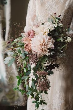 a bridal holding a bouquet of flowers and greenery