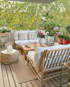 an outdoor living area with white furniture and potted plants on the roof top deck