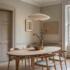 a dining room table with chairs and a vase on it