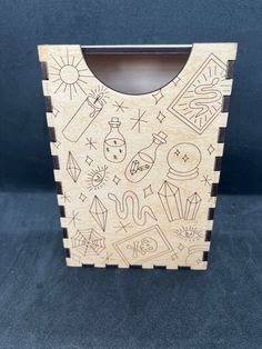 a wooden box that has some drawings on the front and sides of it, with different symbols