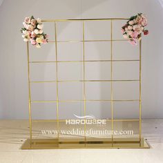 a gold metal frame with flowers on the top and bottom for a wedding ceremony decoration