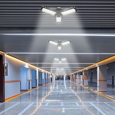 an empty parking garage with lights on the ceiling and doors open to let in light