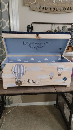 an open box with hot air balloons on it sitting on top of a wooden table