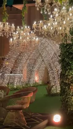 a large chandelier hanging from the ceiling in a room filled with greenery