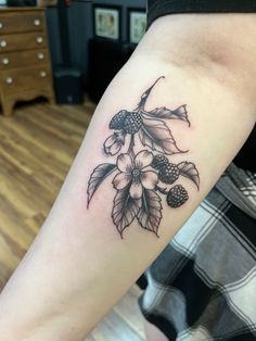 a black and white flower tattoo on the arm