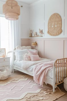 a white bed with pink pillows and blankets on top of it in a bedroom next to a window