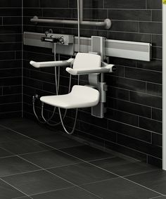 a bathroom with black tiled walls and white chair in the shower area, along with gray tile flooring