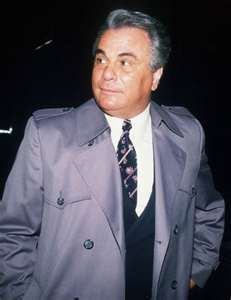 an older man in a trench coat and tie