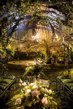 an outdoor wedding venue with flowers and greenery on the tables in front of it