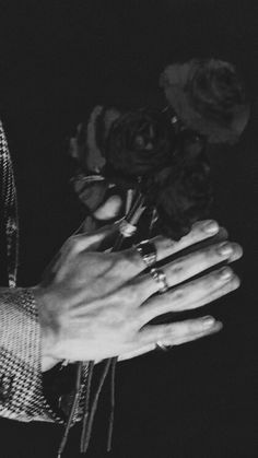 black and white photograph of two hands holding roses