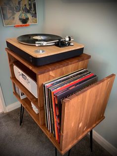 an old record player is sitting on top of a wooden cabinet with vinyl records in it