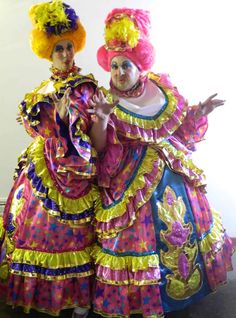 two women dressed in brightly colored costumes posing for the camera