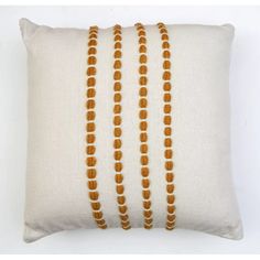 a white pillow with three rows of beads on it