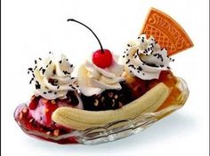 an ice cream sundae with bananas and cherries in a glass dish on a white background